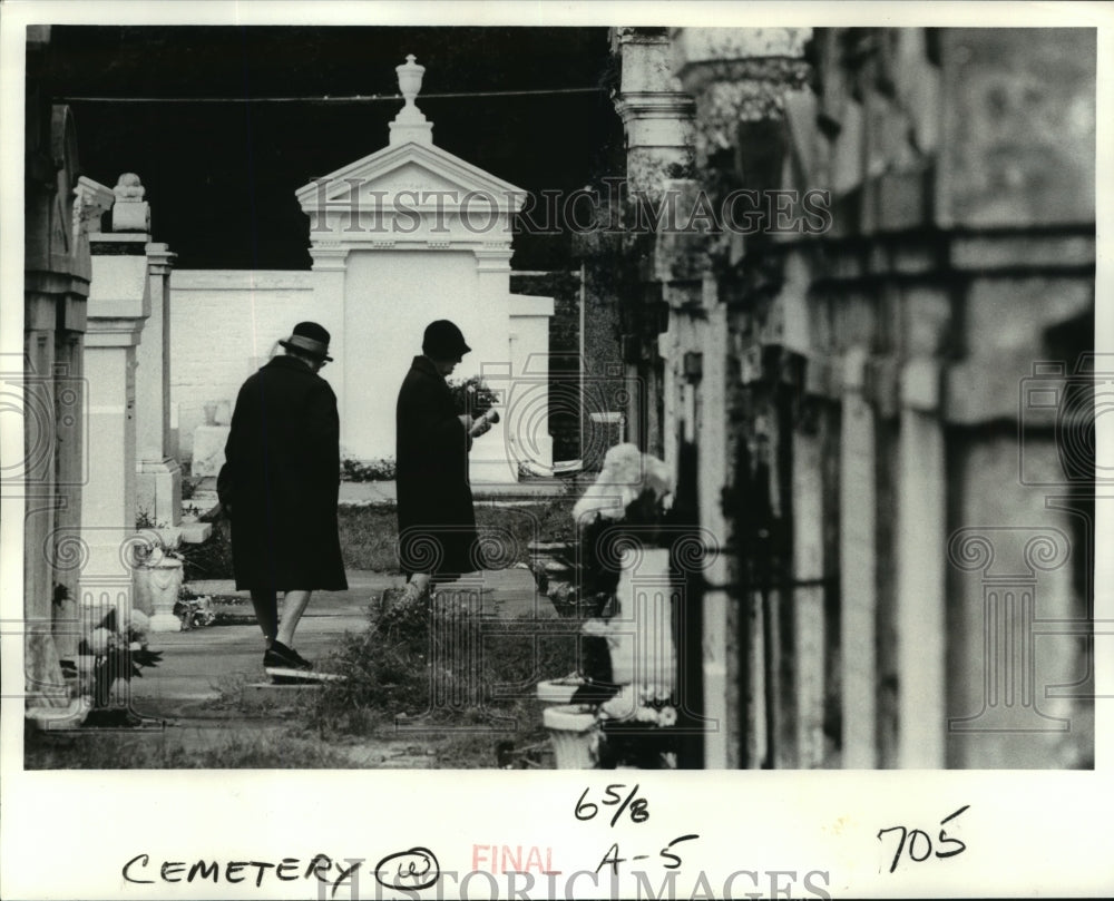 1979 Press Photo Two women carry flowers into Lafayette No 1 Cemetery. - Historic Images