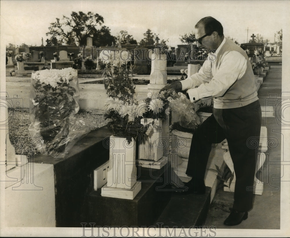 1965 Press Photo All Saints Day - A man places flowers at a family tomb.-Historic Images