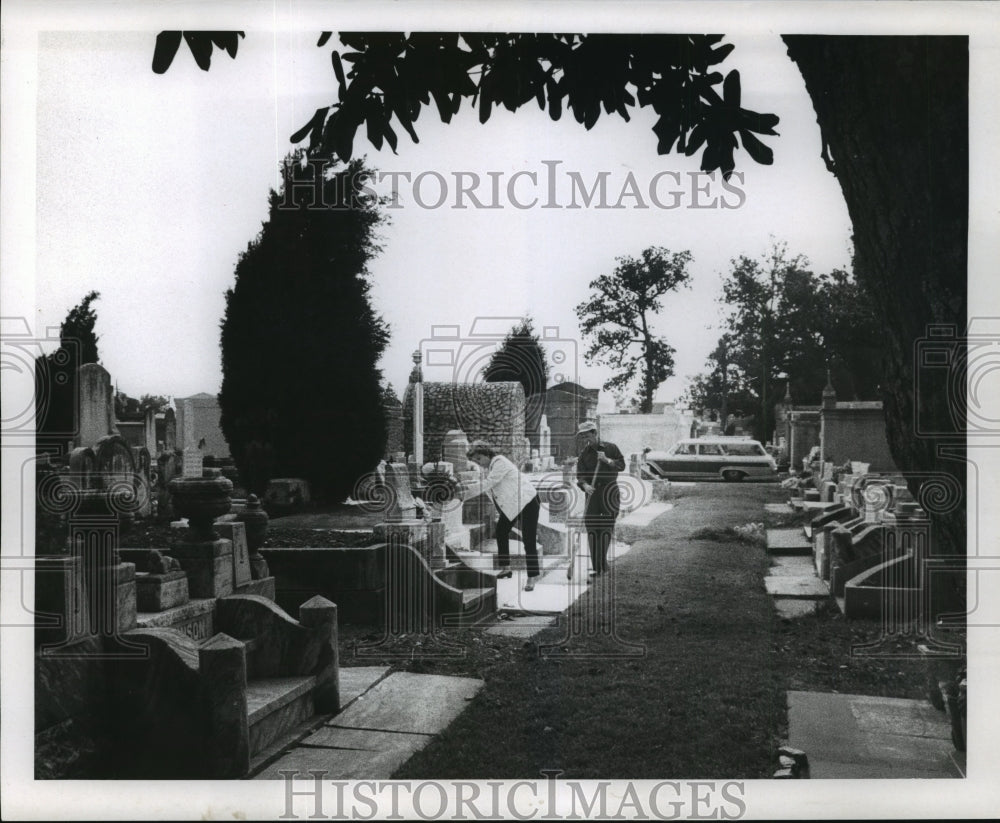 1969 Press Photo All Saints Day - A couple cleans up a family tomb at cemetery. - Historic Images