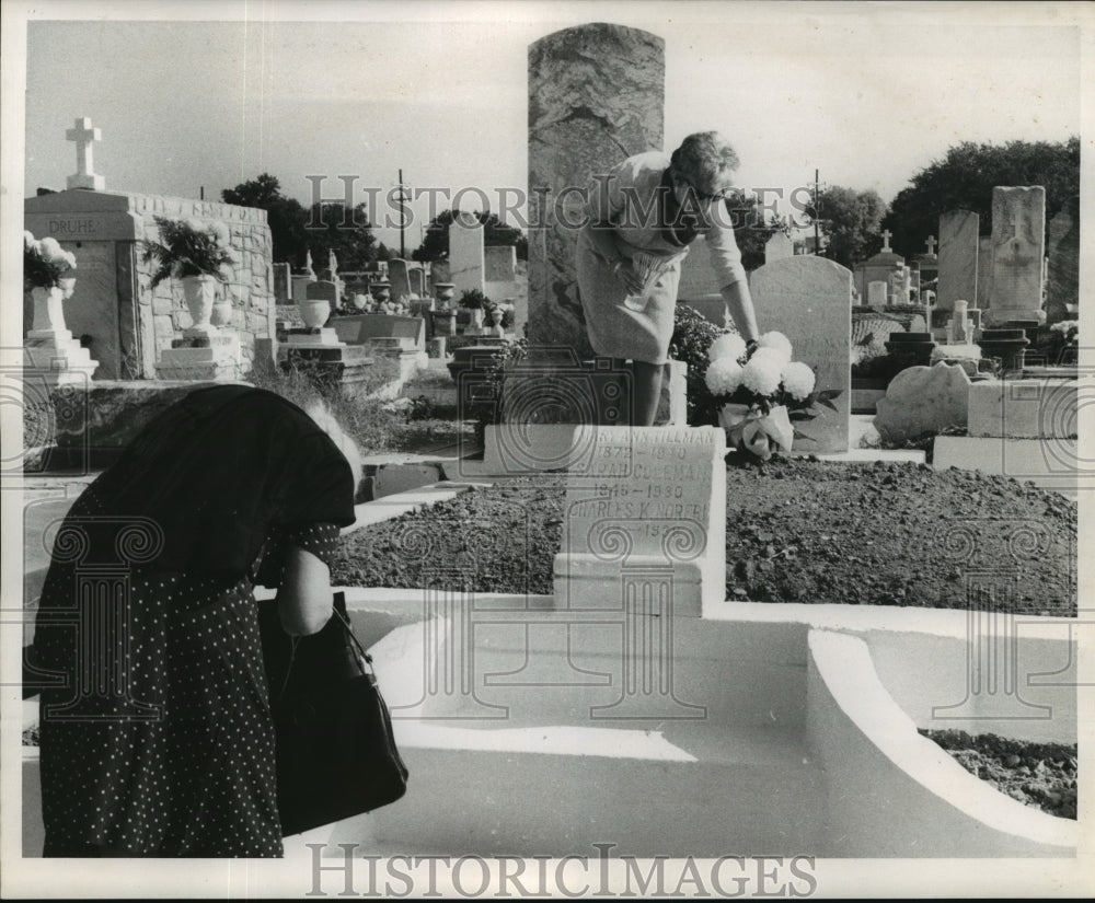 1968 All Saints Day - A woman places flowers at Greenwood Cemetery. - Historic Images