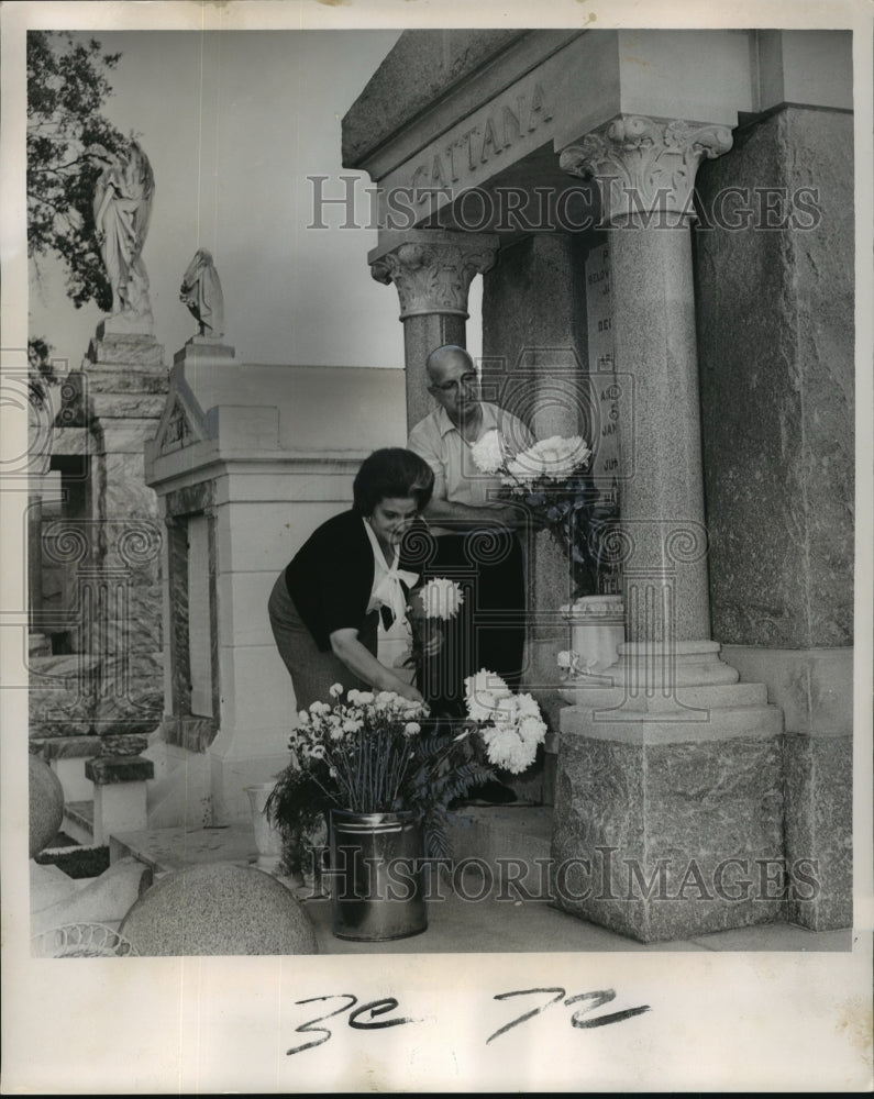 1964 All Saints Day, couple adorns family tomb at Metairie Cemetery - Historic Images