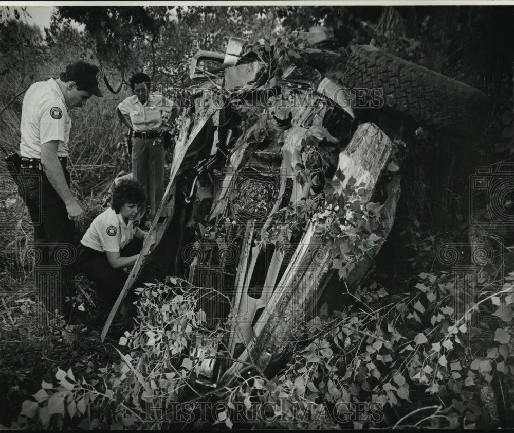 1983 Press Photo Auto Accident- Police officers examine crash off US 90 - Historic Images