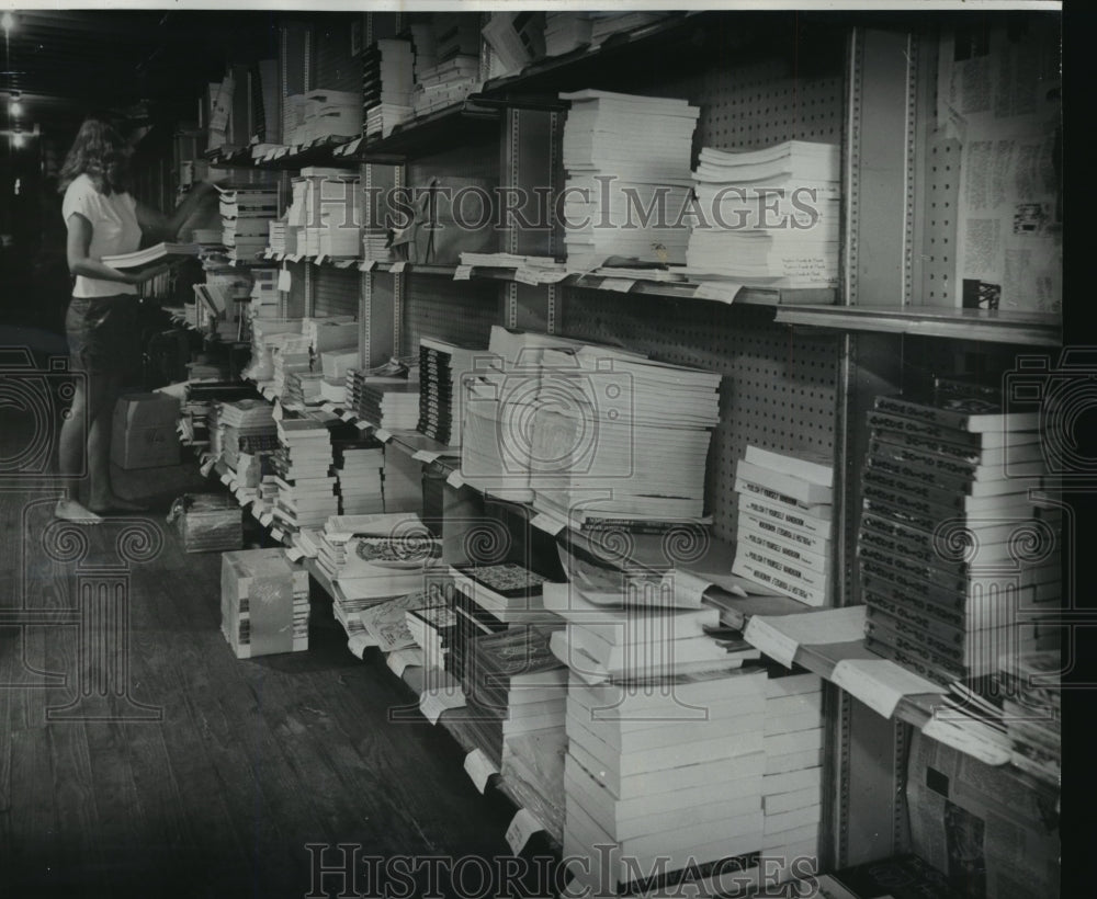 1976 Press Photo Linda Greenhill Arranging Paper Book at Atlantis Distributors - Historic Images