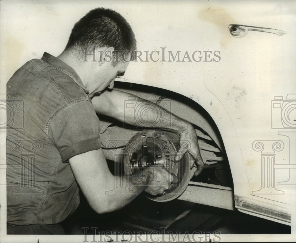 1969 Press Photo Mechanic Inspects Brakes on Vehicle - Historic Images