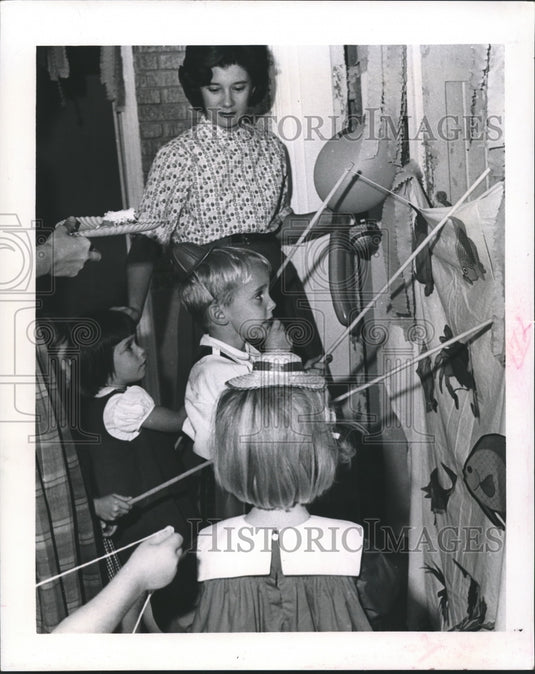 1964 Press Photo Allain Andry, Susan Gibbons "fish" for favors at party-Historic Images