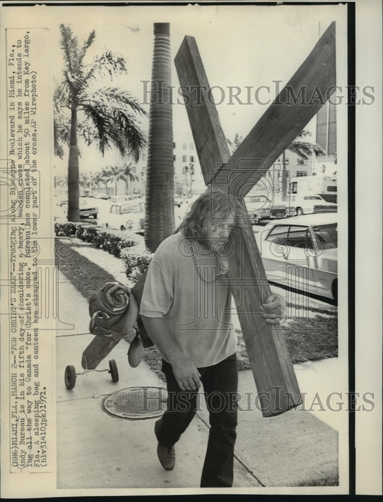 1971 Andy Bureau shouldering a heavy wooden cross in Miami, Florida - Historic Images