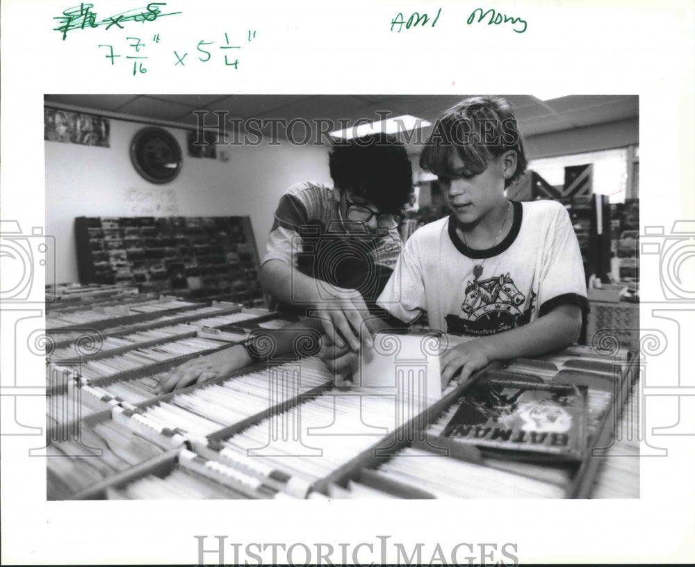 1989 Dwayne Hitzman and John David look through classic comics. - Historic Images