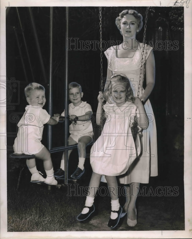 1959 Mrs. John M. Collier with her children on a swing set - Historic Images