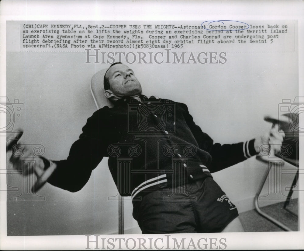 1965 Astronaut Gordon Cooper leans back on an exercising table - Historic Images