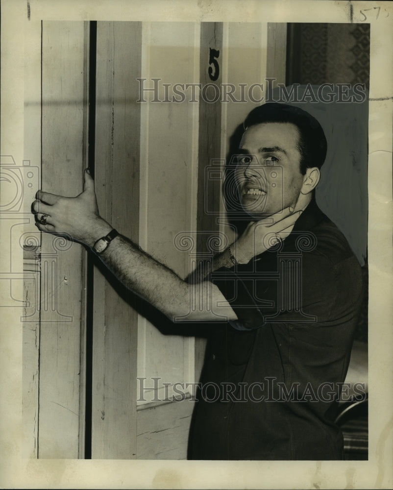 1949 Press Photo Jerry Crocker, a hotel clerk, shows how bandits choked him - Historic Images