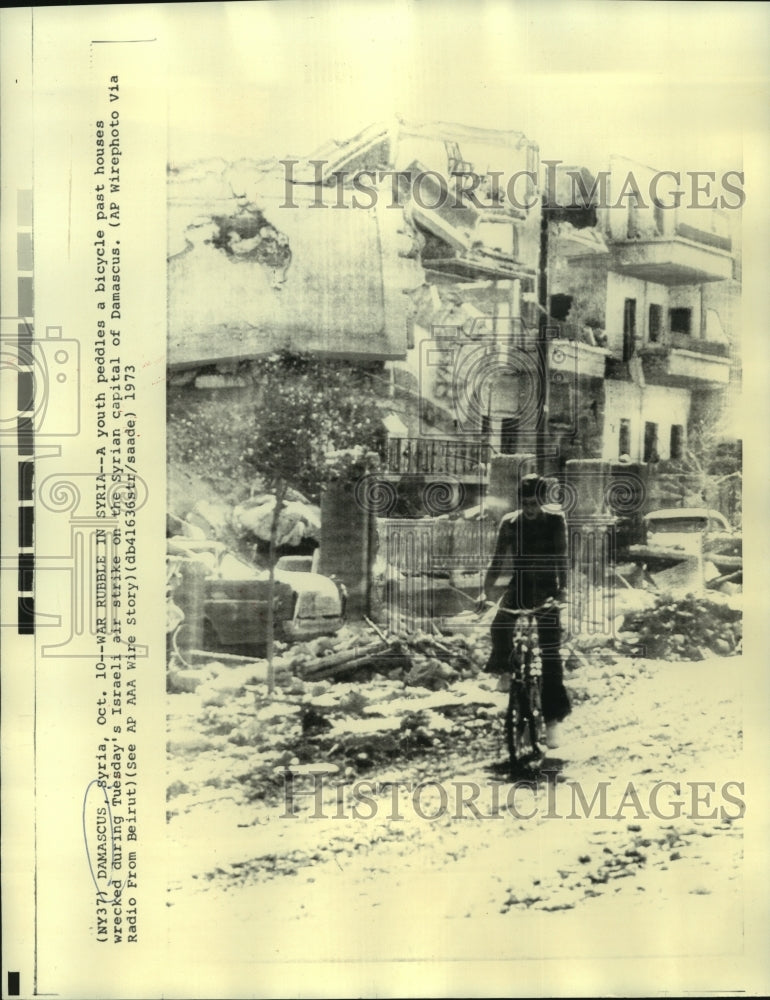 1973 Press Photo Youth rides bike down Israeli air struck streets of Damascus - Historic Images