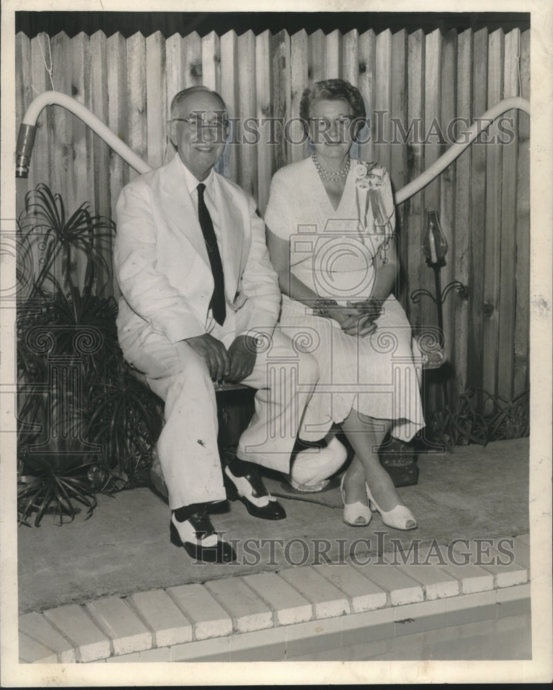 1959 Mr. and Mrs. Abraham H. Diaz sit near pool - Historic Images