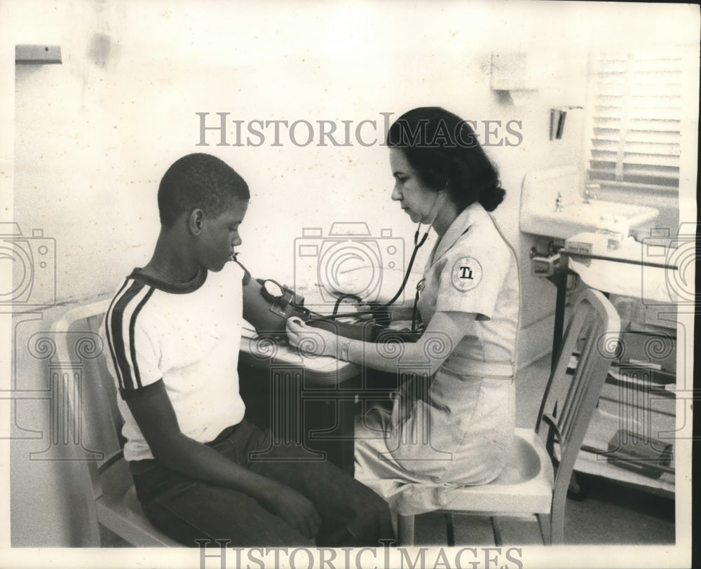 1968 Lucille Lord checks patient Daitrone Kennedy of Touro clinic - Historic Images
