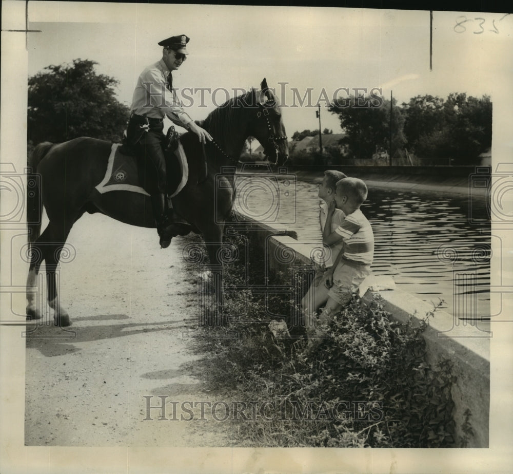 1955 Press Photo Patrolman Dennis Bergeron on patrol at the London Avenue Canal - Historic Images