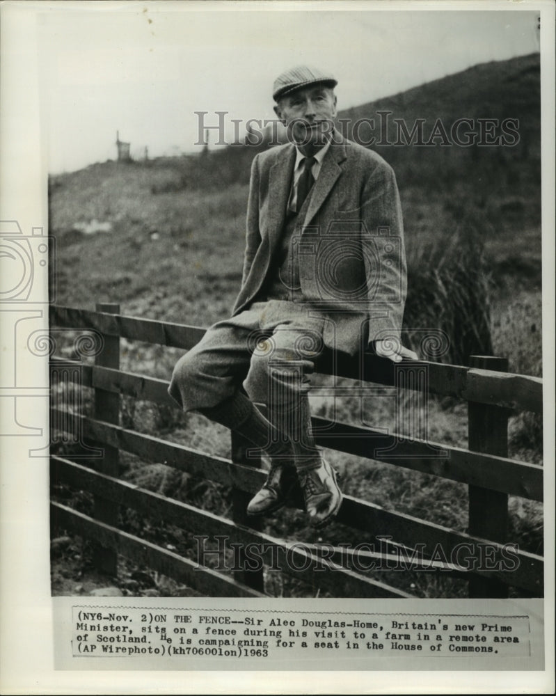 1963 Press Photo British Prime Minister Sir Alec Douglas-Home, sits on a fence - Historic Images