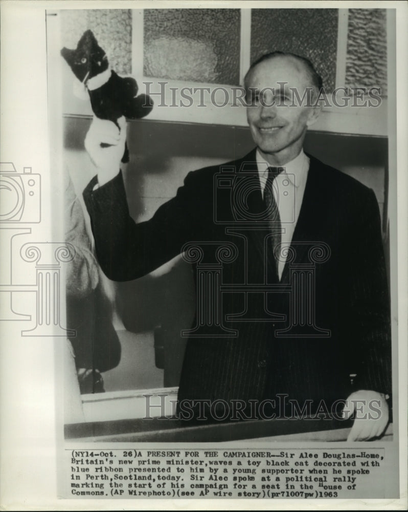 1963 Press Photo British Prime Minister Sir Alec Douglas-Home waves a toy cat - Historic Images