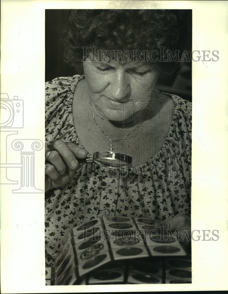 1986 Press Photo Thelma Breaux, Marrero, magnifies her Mardi Gras doubloons - Historic Images