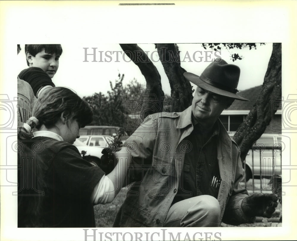 1992 Press Photo Rebecca Melerine, hands a flower to horticulturist S. Doughty. - Historic Images