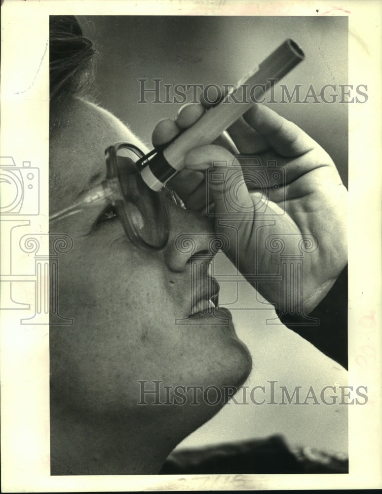1985 Press Photo Firefighter checks her dosimeter to measure radiation exposure - Historic Images