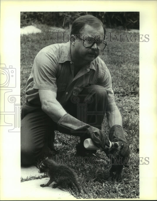 1991 Press Photo "Trapper" Greg duTreil feeds raccoons in the Metairie area - Historic Images