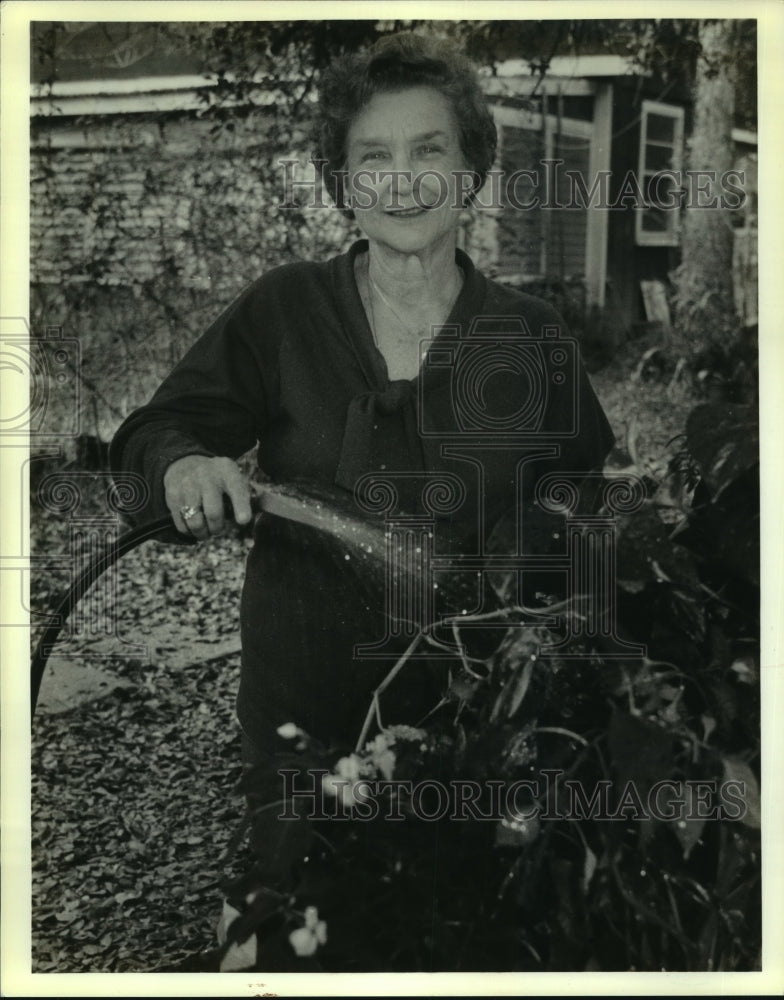 1990 Press Photo Gerry Ebeling waters some of her many varieties of plants - Historic Images