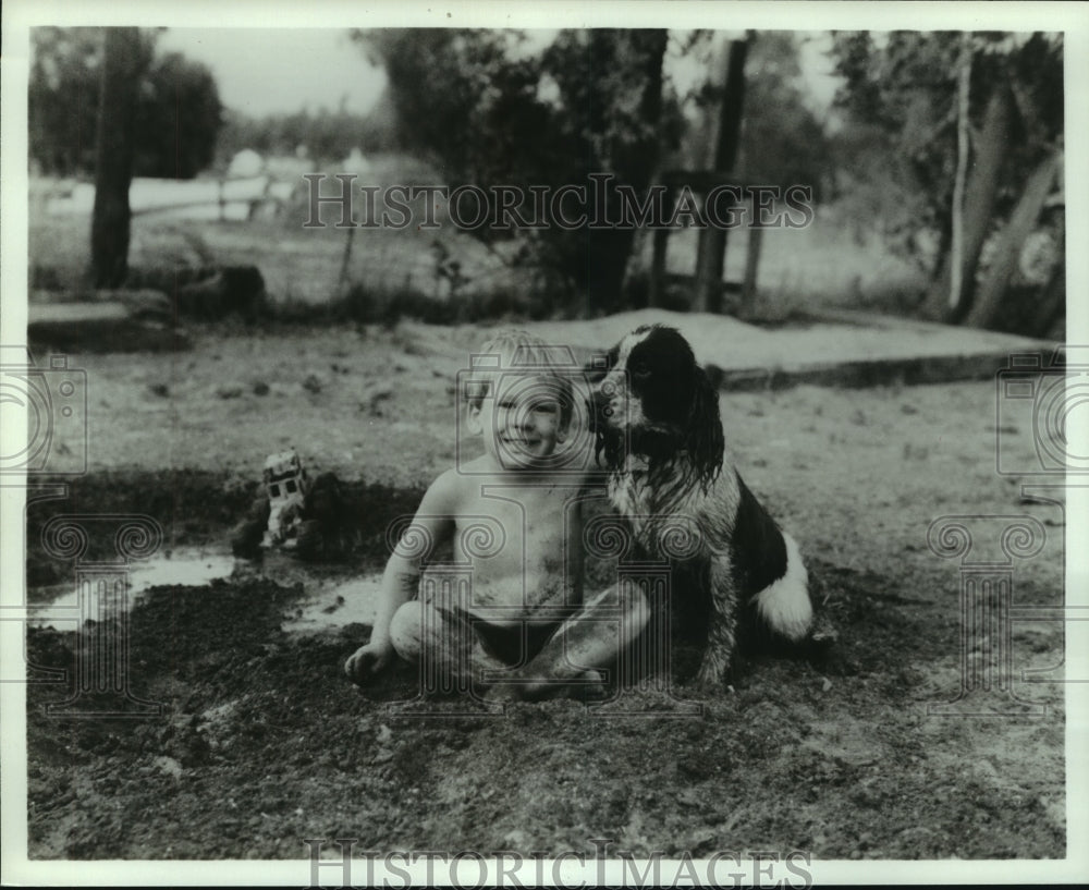 1984 Press Photo Young Boy and Dog Play in Mud - noa95686 - Historic Images