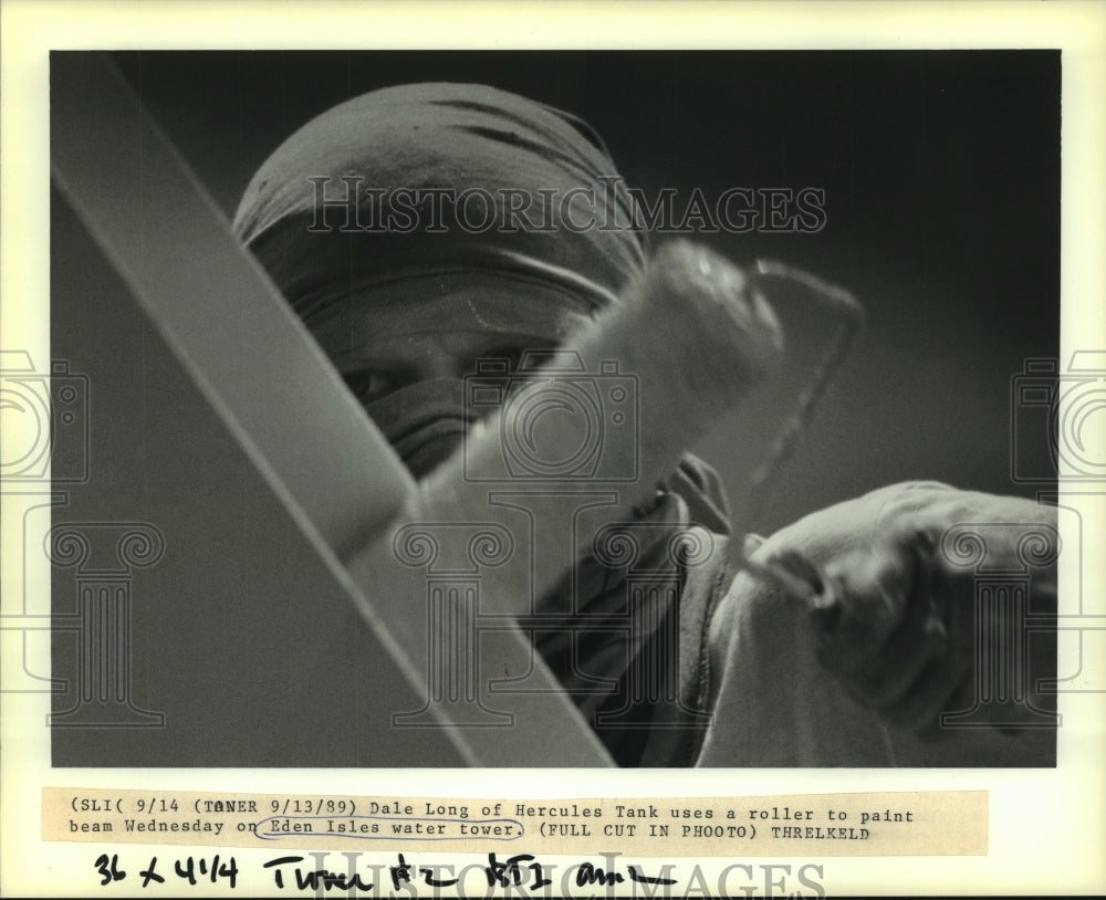 1989 Press Photo Dale Long uses a roller to paint beam on Eden Isles water tower - Historic Images