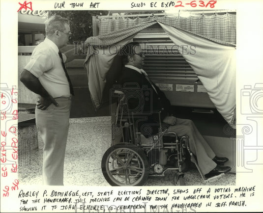 1985 Press Photo Robley Domingue shows John Eckerle handicapped voting machine. - Historic Images