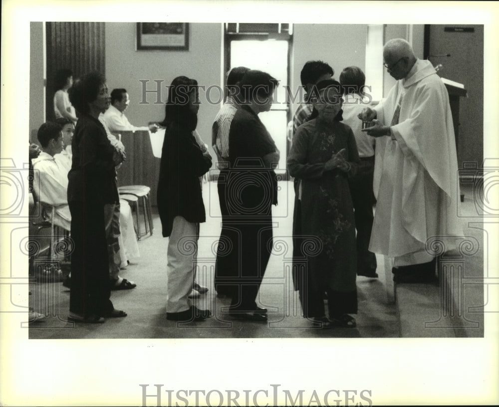 1995 Press Photo Reverend Joseph Ngo Duy-Linh gives communion at Mary Mission - Historic Images