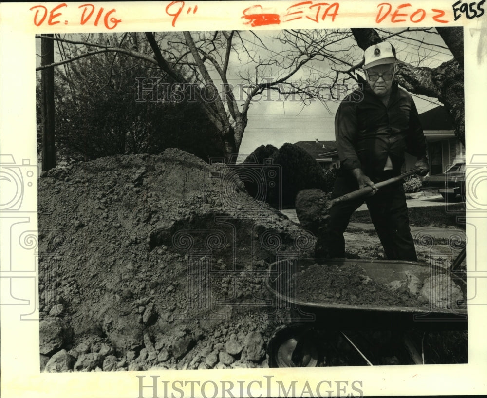 1982 Press Photo Frank Duvernay moves dirt from large pile to his garden. - Historic Images