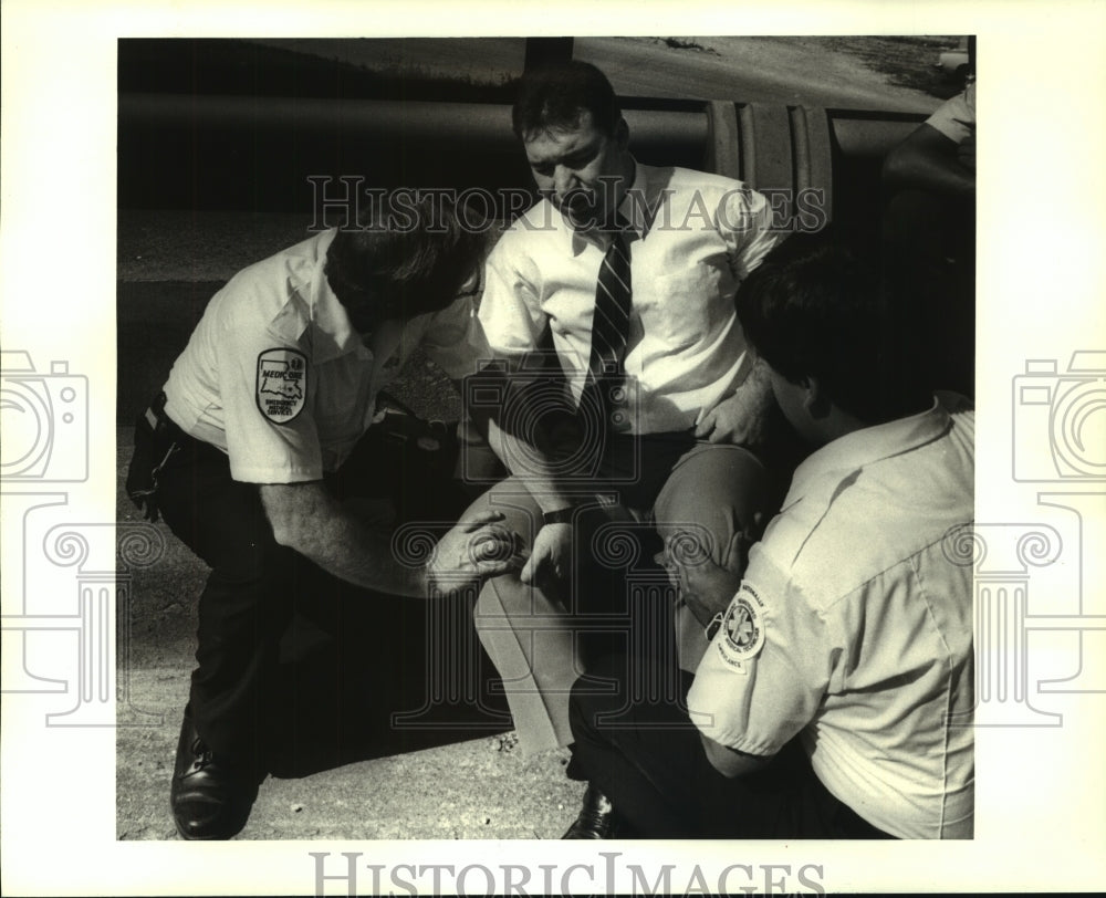 1987 Press Photo Medic One Emergency Medical Services checks accident victim - Historic Images