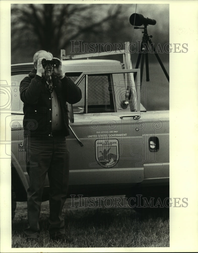 1983 Press Photo An Employee of Fish and Wildlife looking at a Bald Eagle. - Historic Images