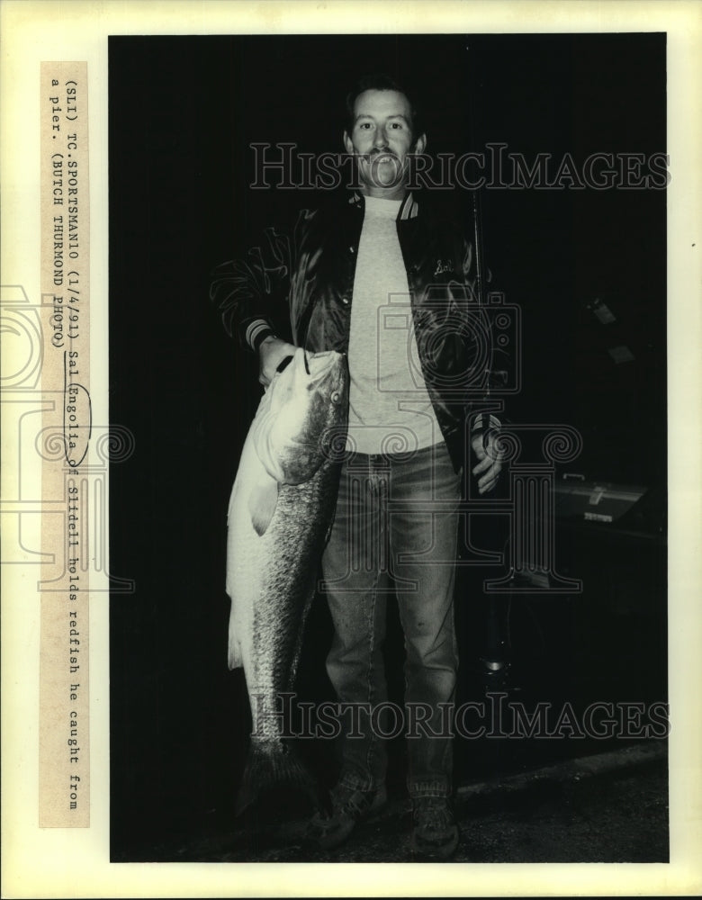 1991 Press Photo Sal Engolia of Slidell holds redfish he caught from a pier - Historic Images