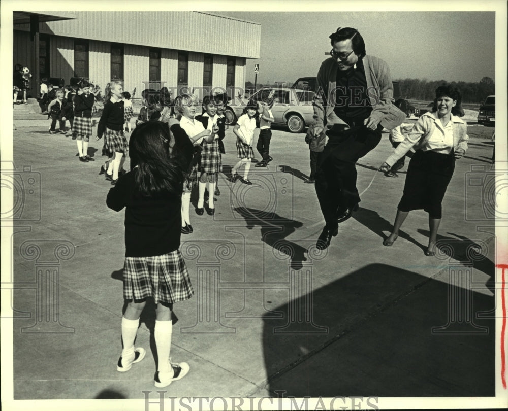 1984 Press Photo Reverend Joseph Duc Dzien plays with students at LaPlace School - Historic Images