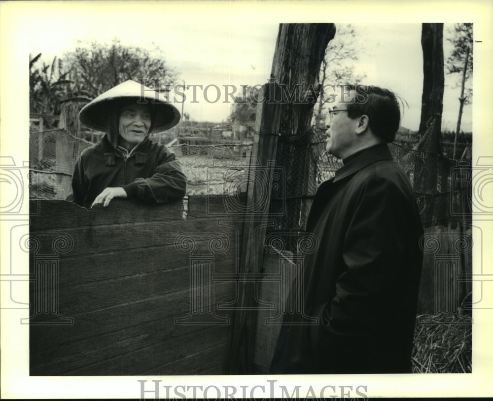 1989 Press Photo Father Dominick speaking over the fence with a constituent. - Historic Images