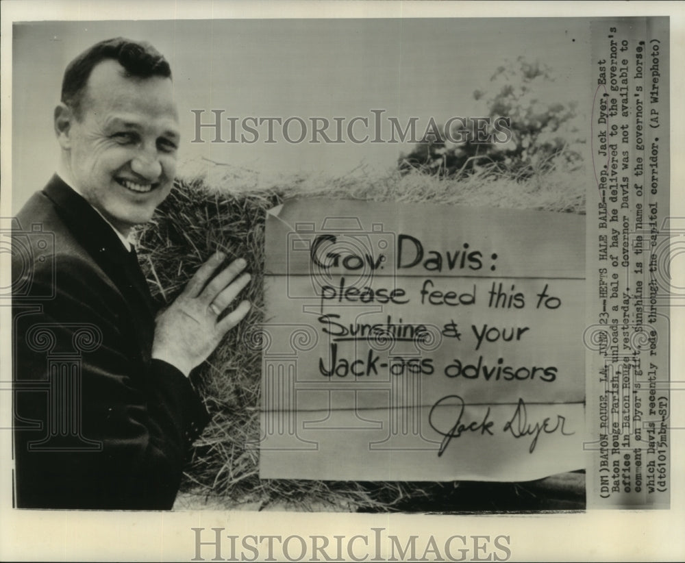 1961 Press Photo Rep. Jack Dyer unloads a bale of hay as gift for Governor Davis - Historic Images