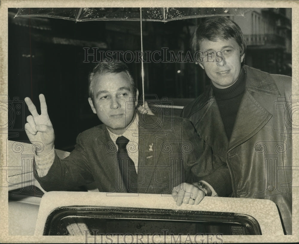 1972 Edwin Edwards giving peace sign &amp; unknown man holding umbrella - Historic Images