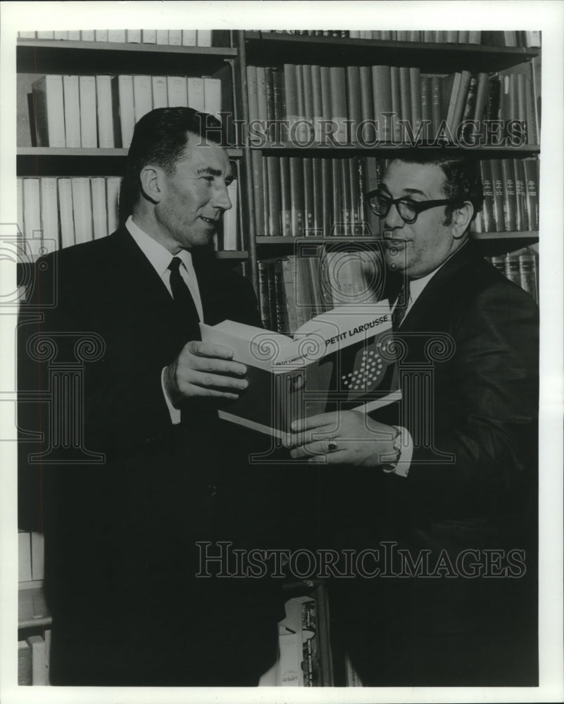 1969 Press Photo Edouard Faguer examining Petit Larousse, a French dictionary. - Historic Images