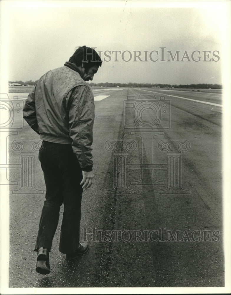 1979 Stan Jurgelsky, examines a crash on the airport runway. - Historic Images