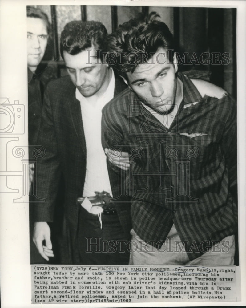 1963 Press Photo Gregory Egan shown in police headquarters with a patrolman. - Historic Images