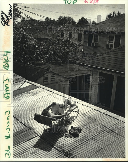 1988 Press Photo Julie Elliott reclines on a roof & studies for her night class - Historic Images