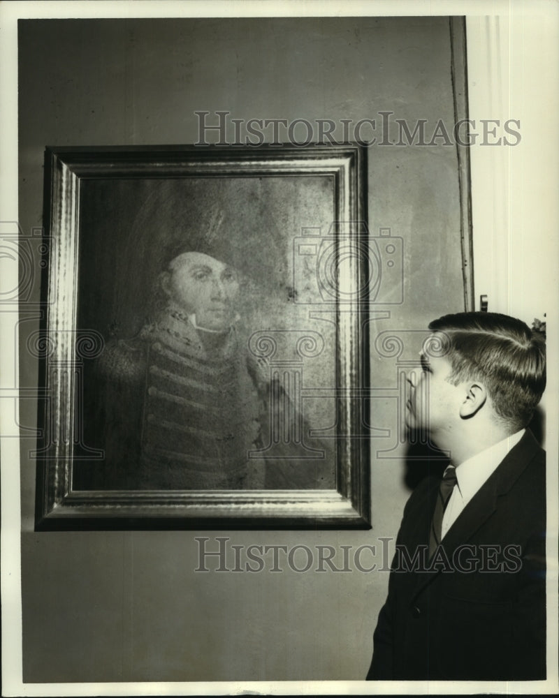 1965 Press Photo Alfred C. Denis looks at painting of ancestor Major Carmick. - Historic Images