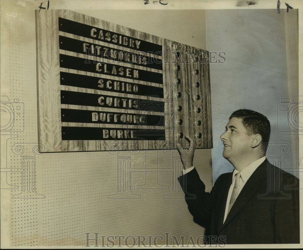 1957 Press Photo Councilman Paul Burke examines City Council voting tally board - Historic Images