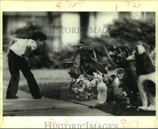 1988 Press Photo Donald Fernandez checks out ceramic animals at garage sale - Historic Images