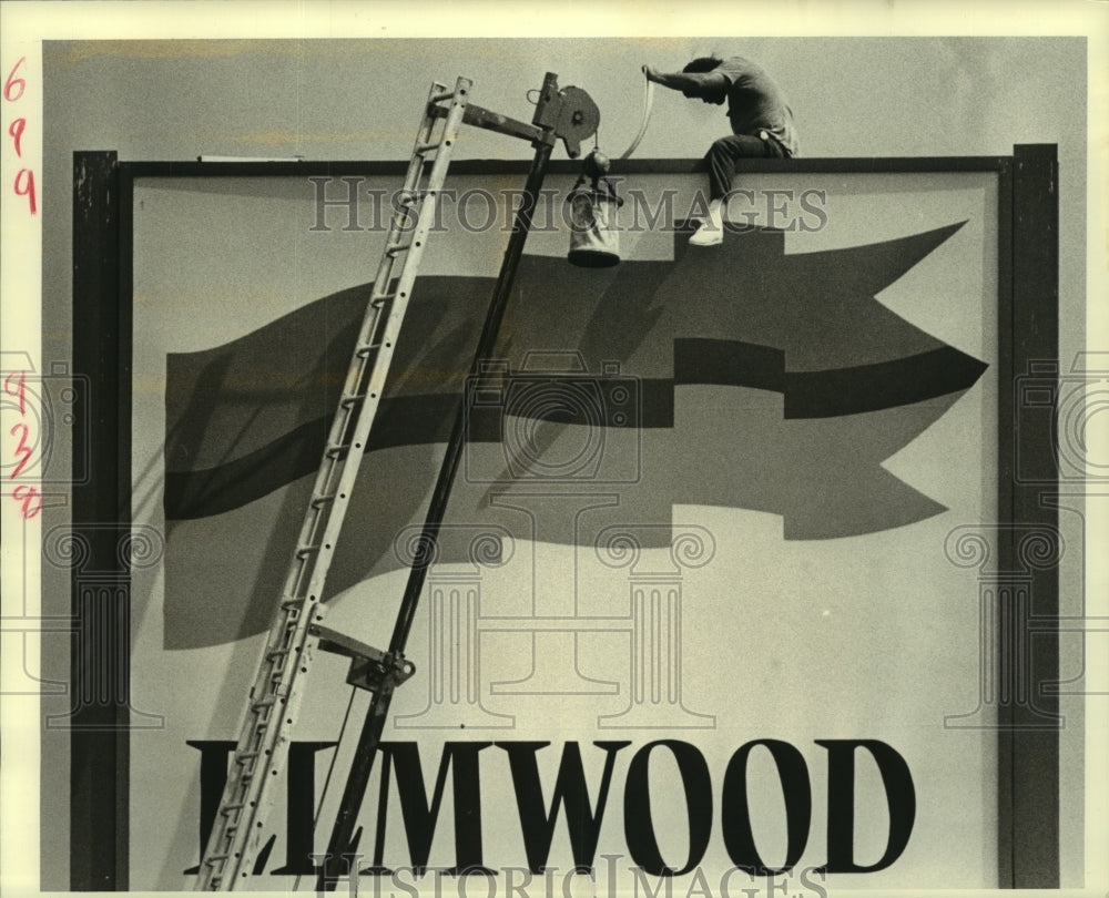 1989 Press Photo A repair worker on sign for Elmwood Shopping Village Center - Historic Images