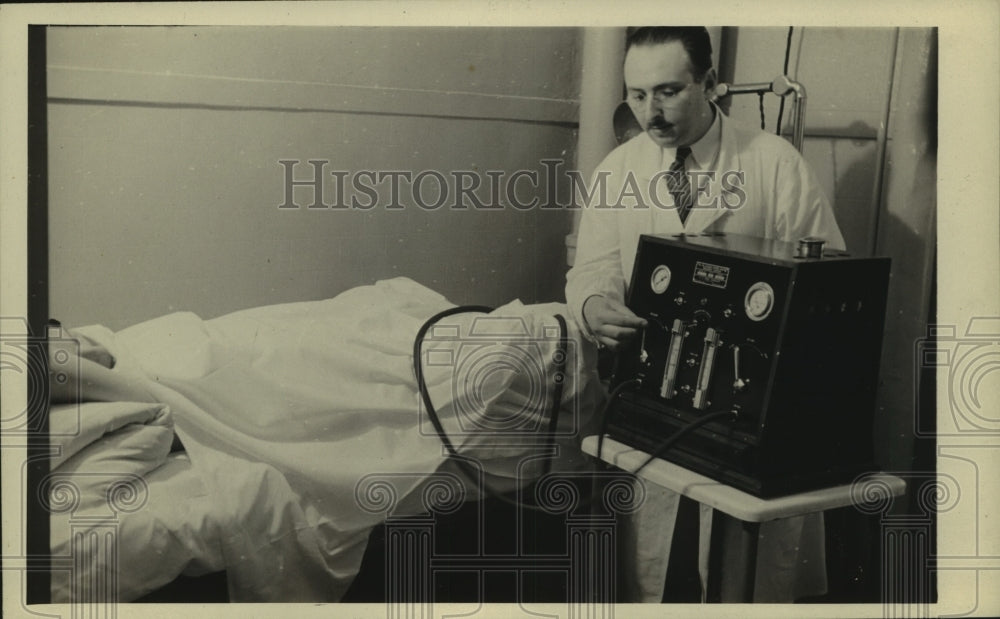 Doctor working with patient in hospital - Historic Images