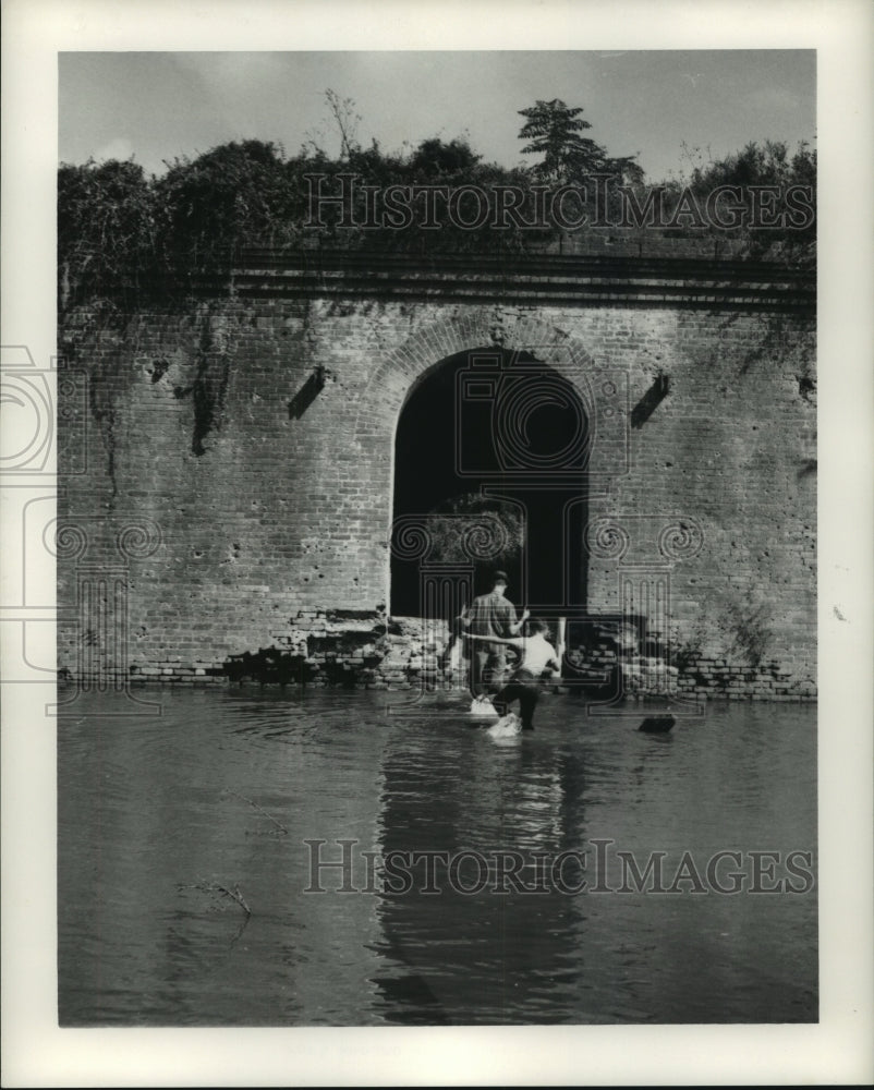 1964 Press Photo Workmen cross the water to get to the entrance of Fort Macomb - Historic Images