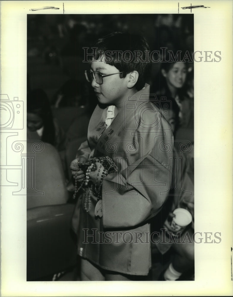 1990 Press Photo Masayuki, Kagiura, holds Mardi Gras Beads - Historic Images