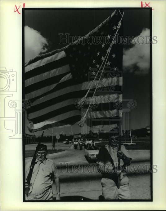 1990 Press Photo Veterans' Day Parade marchers bear flags and rifles - Historic Images