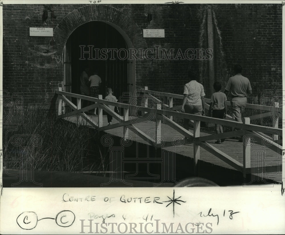 1969 Press Photo Visitors crossing moat into Ft. Pike notice a No Fishing sign. - Historic Images